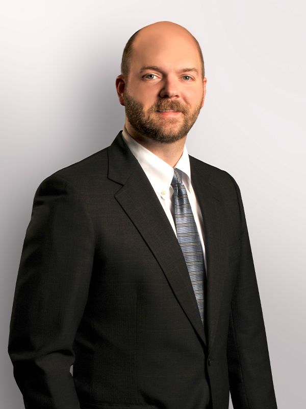 a man wearing a suit and tie smiling at the camera