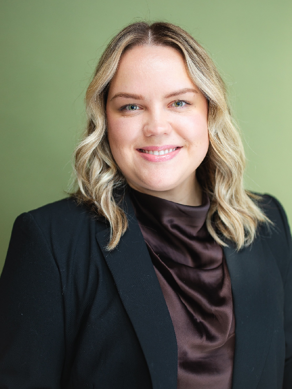 a person wearing a suit and tie smiling at the camera